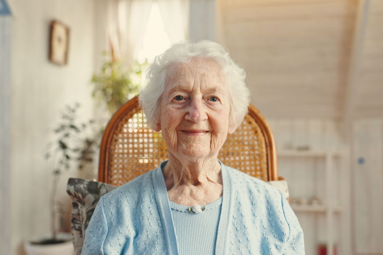 An elderly woman smiles.