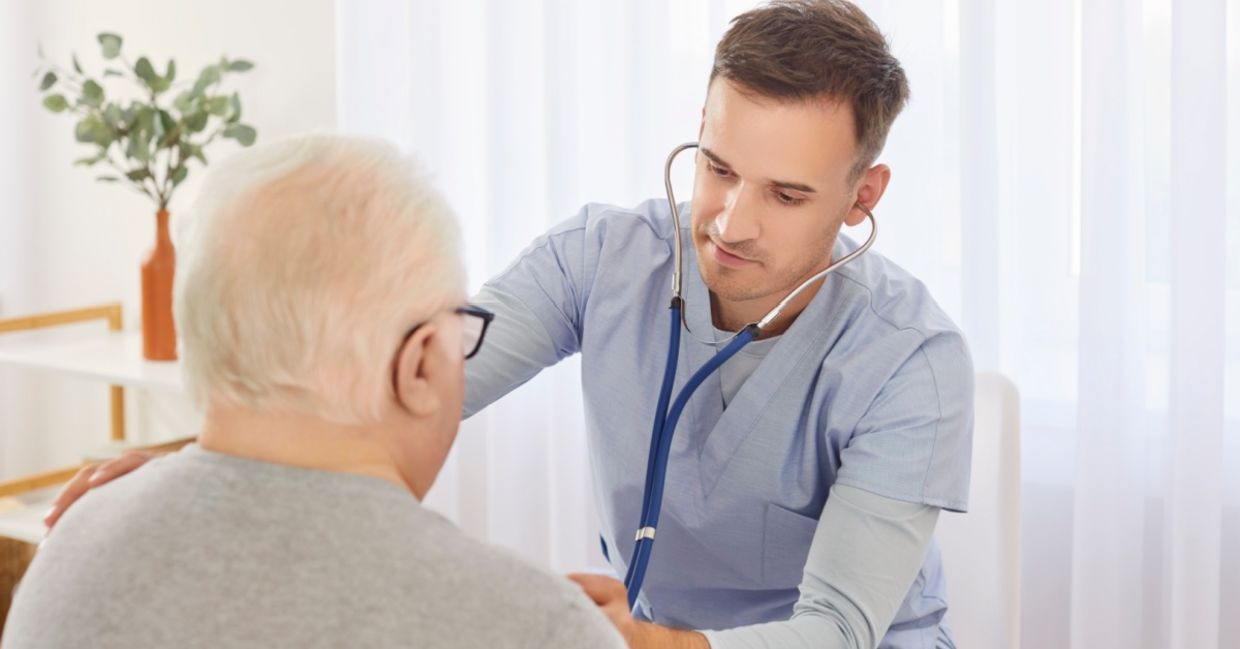 Young doctor examining an elderly patient.