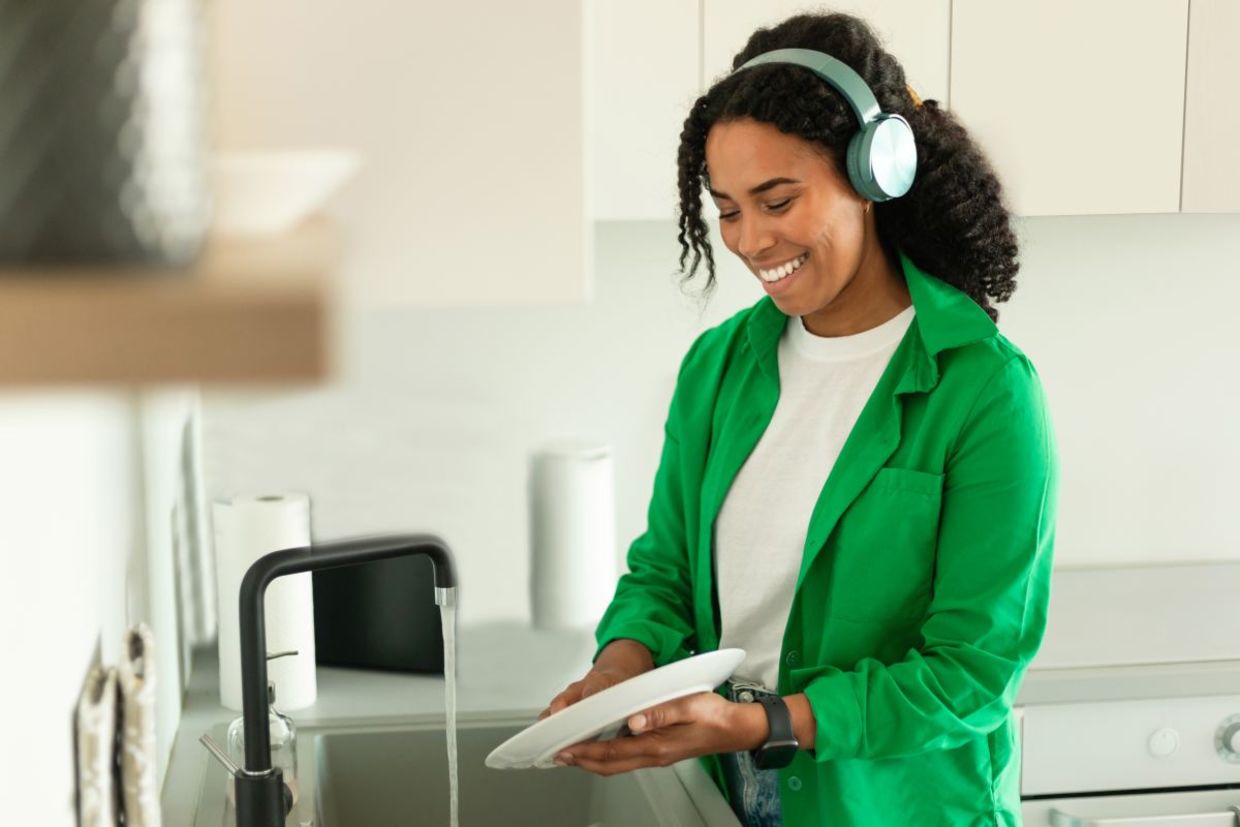 Woman listening to an audiobook while doing dishes.