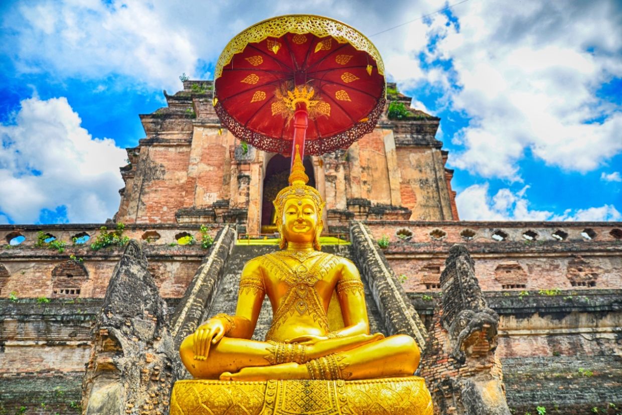 A pagoda and buddha statue at Wat Chedi Luang temple in Chiang Mai.