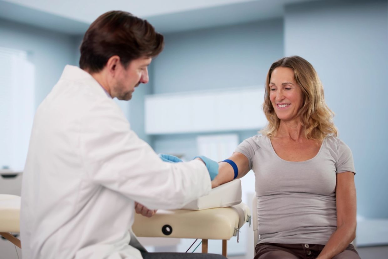 A doctor draws blood from a person.