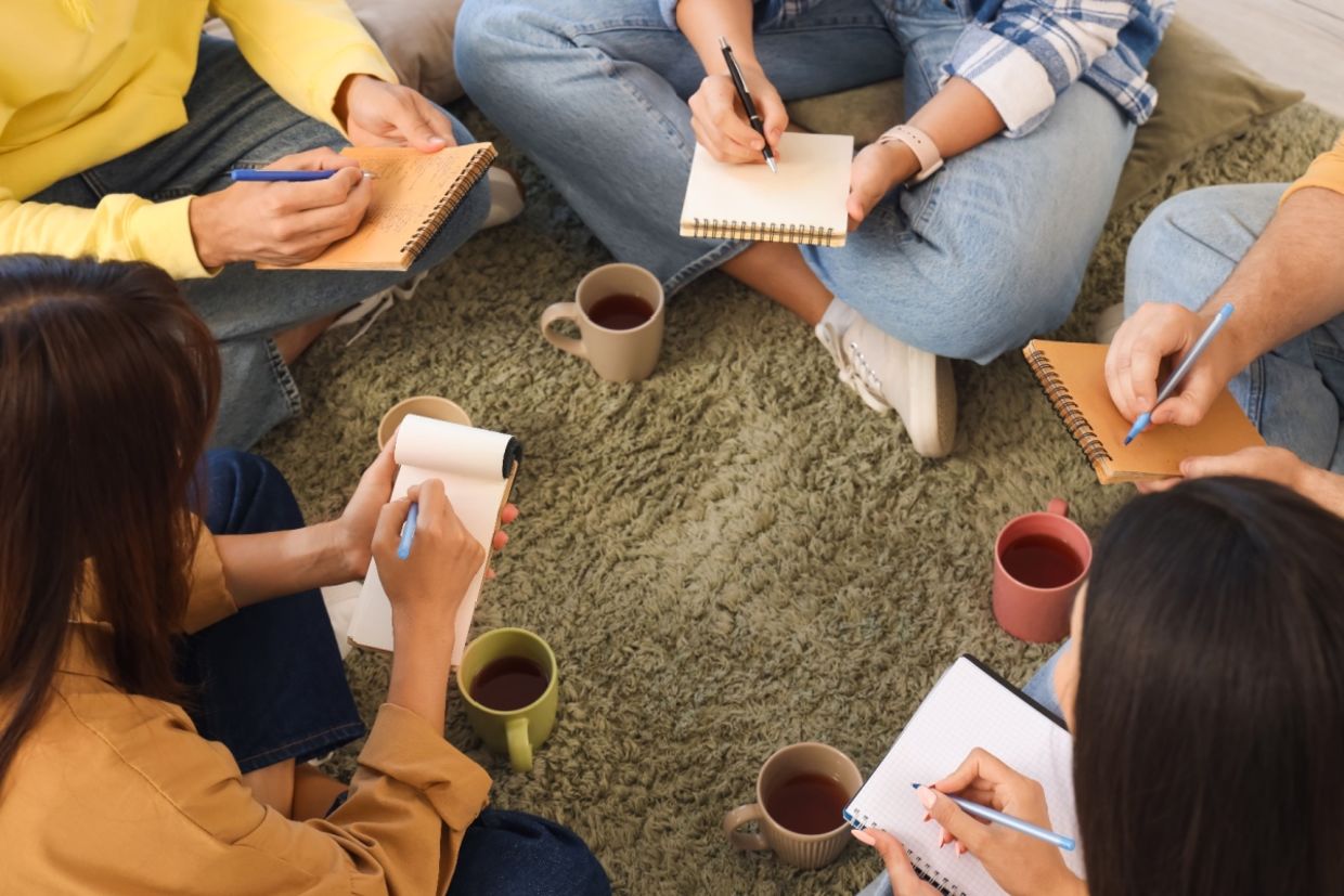 Young people write in notebooks.
